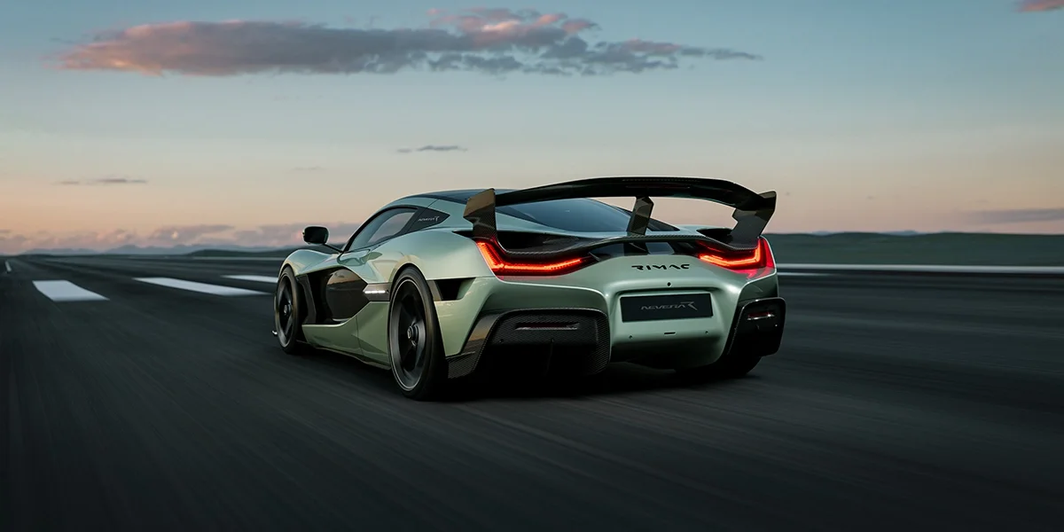 Side profile of the Rimac Nevera R driving through mountain roads at golden hour, demonstrating its streamlined silhouette and carbon-fiber elements.